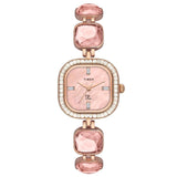 A TIMEX Fria women's watch with a white dial, round case, and pink gemstone accents on the bezel.