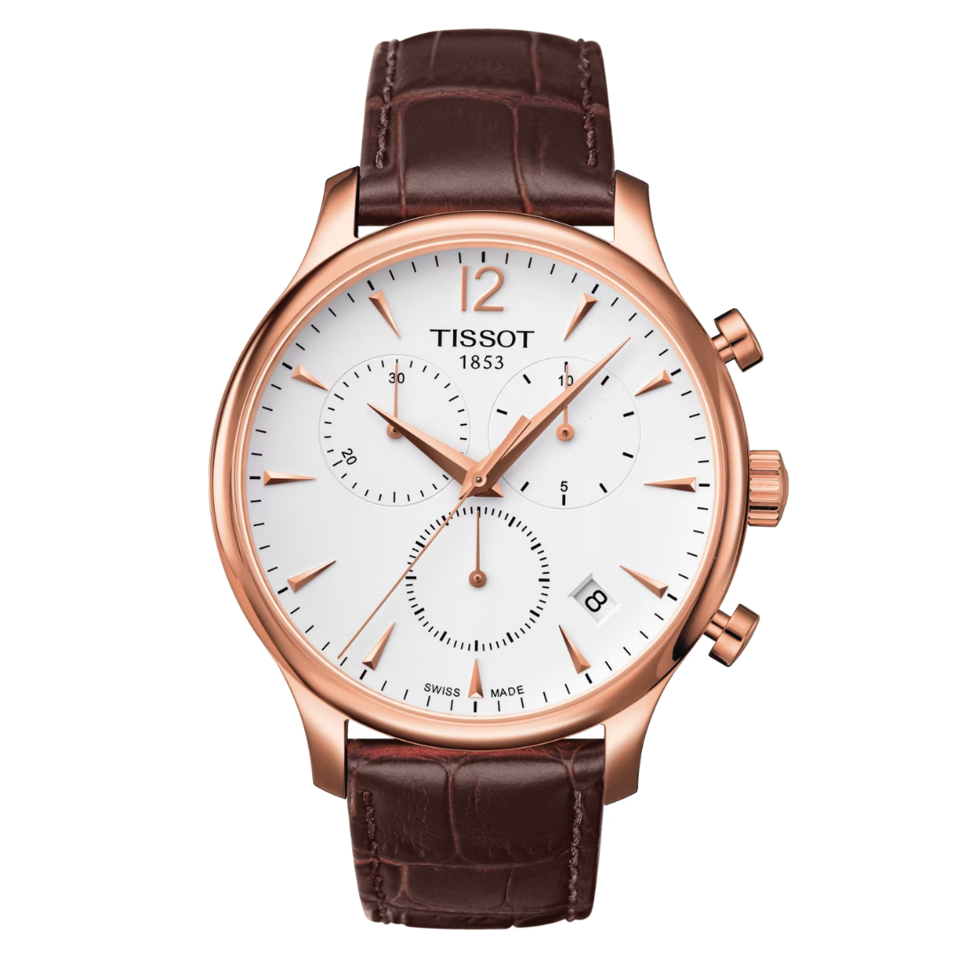 A TISSOT Tradition Chronograph watch with a white dial, rose gold case and bracelet, and a brown leather strap.